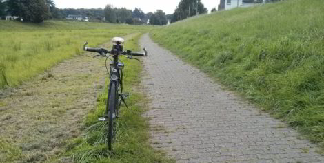 Die Reifen meines Fahrrades stehen genau auf der Begrenzungskante der Pflastersteine.