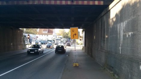 Umleitungsschild mitten auf dem benutzungspflichtigen Radweg in der dunklen Unterführung.