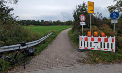 Die Einmündnung eines Geh- und Radweges, welche mit einem "Durchfahrt verboten in 400m" und einem Umleitungsschild gekennzeichnet ist.