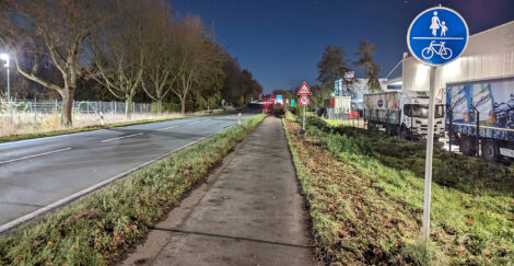 Ein kombinierter Geh- und Radweg mit entsprechender Beschilderung. Etwas versetzt nach hinten ist ein "Achtung Fahrräder"-Zeichen und darunter eine Geschwindigkeitsbeschränkung auf 50 km/h zu sehen.