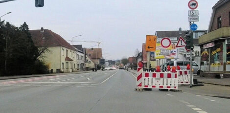 Eine zweispurige leere Straße mit diversen Schildern am rechten Rand und auf der rechten Fahrbahn, welche auf eine Sperrung hinweisen.