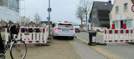 Fast geschafft. Ein weißes Auto fährt rückwärts aus einem schmalen Gehweg heraus.