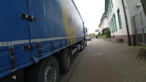 Ein LKW fährt mit Zentimeterabstand auf der Fahrbahn neben einem Hochbordradweg.