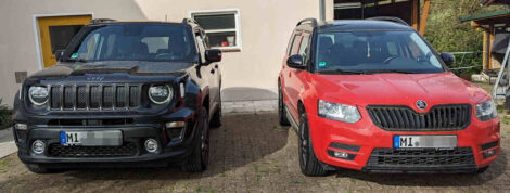 Ein schwarzer Jeep Renegade steht neben einem rot schwarzen Skoda Yeti.