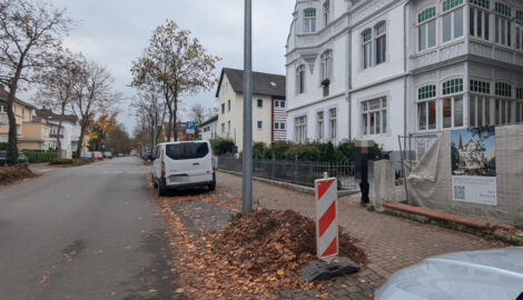 Neben einer Straßenlaterne sieht man die Stelle, an welche einmal ein Baum stand. Nur noch ein wenig Häcksel erinnert daran. Im Hintergrund parkt ein Trasnsporter.