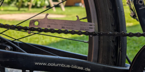 Eine Kettenlehre steckt in einer Kette an einem Fahrrad und es ist deutlich sichtbar, dass die Kette viel zu sehr gelängt ist.