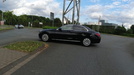 Ein dunkler Mercedes fährt entgegen der Fahrtrichtung in einem Kreisel.