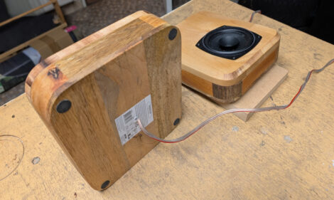 Zwei kleine Lautsprecherboxen mit 10 Zentimeter großen Chassis und den Lautsprecherkabeln.
