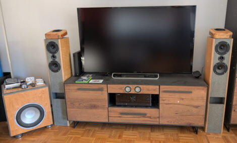 Eine Heimkinoanlage mit einem 65-Zoll-Flachbildschirm, zwei großen Frontlautsprechern, einen Subwoofer, einem in den Hifischrank integrierten Centerlautsprecher und den neuen Dolby-Atmos-Aufsätzen.