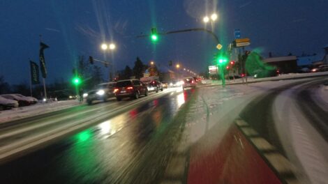 Ein rot markierter Radstreifen vor einer Ampel. Links daneben ist die schneefreie Fahrbahn, rechts ein fast schneefreier Rechtsabbiegstreifen. Der Fahrradstreifen ist mit Schnee und Eis bedeckt.