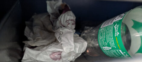 Eine zusammengeknüllte Papiertüte neben einer PET-Flasche.
