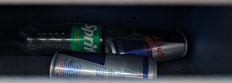 Eine PET-Flasche neben zwei Aluminium-Dosen.