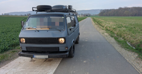 Ein VW Bulli mit Reserverad und Ersatzbezinkanister auf dem Dachgepäckträger auf einer als Geh- und Radweg ausgeschilderten Straße