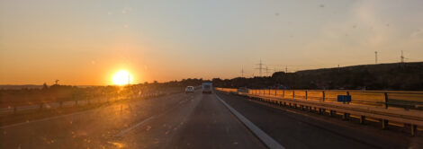 Die Sonne geht hinter den Hügeln einer Autobahn auf.