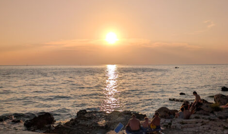 Die Sonnen flach über dem Horizont des Meeres am Strand von Kroatien.
